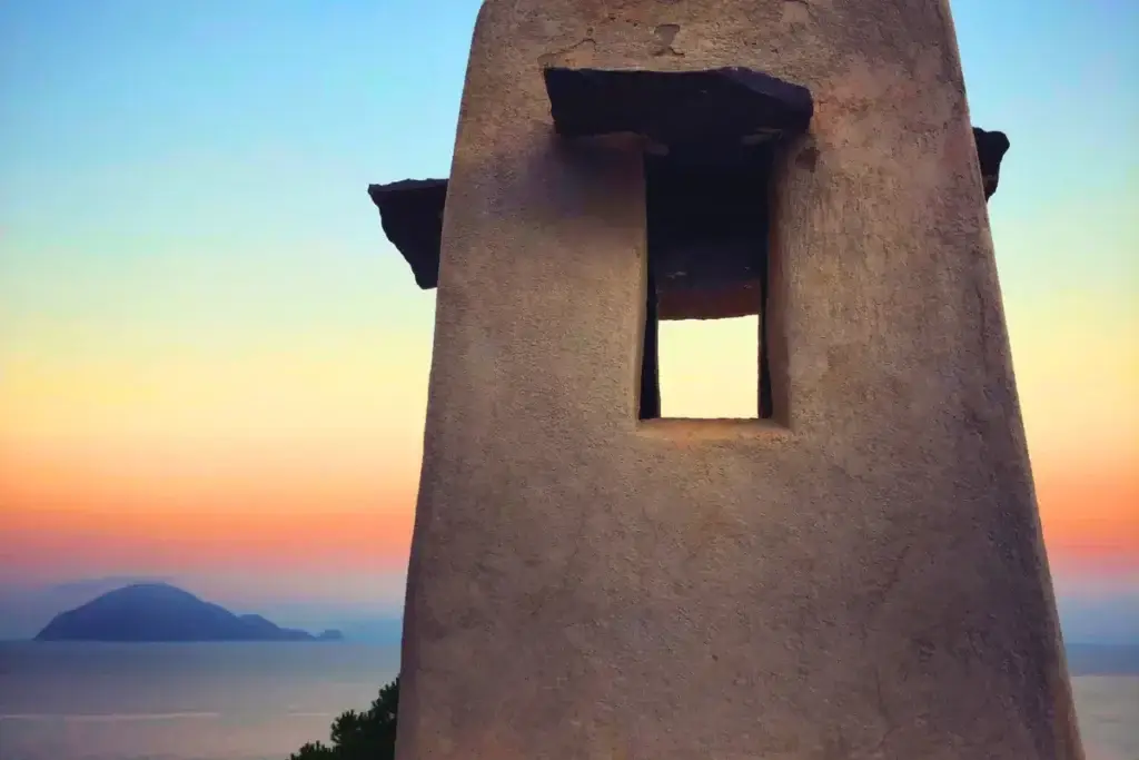 Camino tradizionale di Alicudi in primo piano con vista sull’isola di Filicudi al tramonto, Isole Eolie