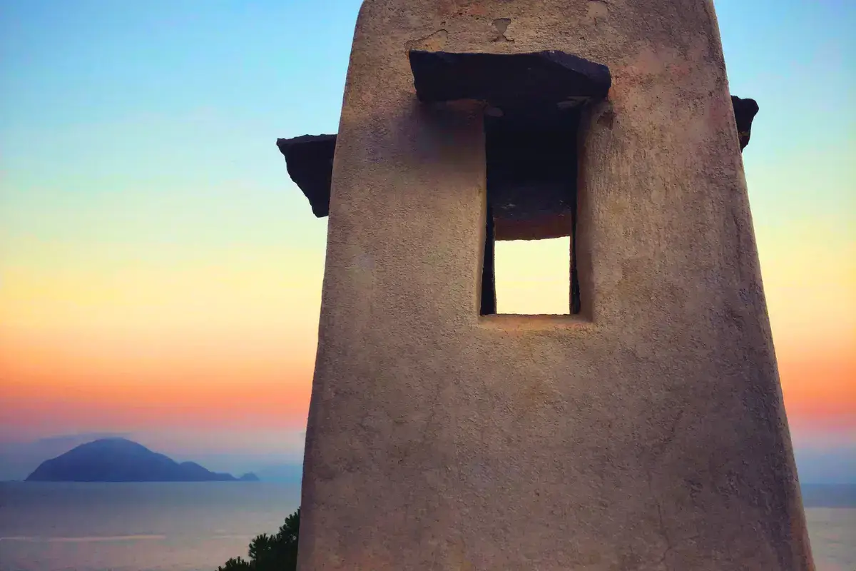 Camino tradizionale di Alicudi in primo piano con vista sull’isola di Filicudi al tramonto, Isole Eolie