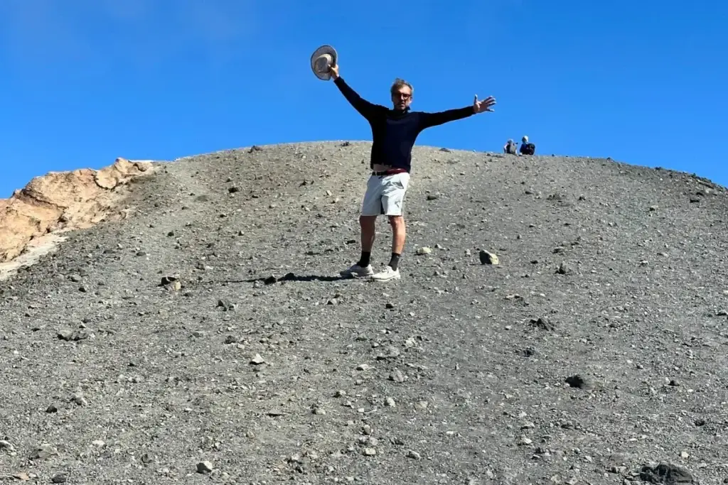 Escursionista in cima al Gran Cratere dell’isola di Vulcano, sotto un cielo azzurro, Eolie