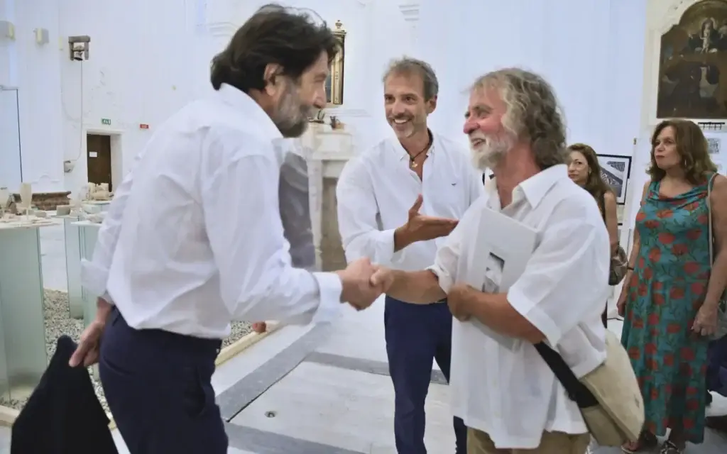Massimo Cacciari saluta ospiti e pubblico durante un incontro al Festival EOLIÈ nelle Isole Eolie, evento dedicato ad arte, letteratura e società.
