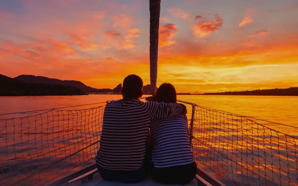 Coppia abbracciata su una barca al tramonto nelle Isole Eolie – immagine simbolo del Festival EOLIÈ, tra intimità e paesaggio mediterraneo.