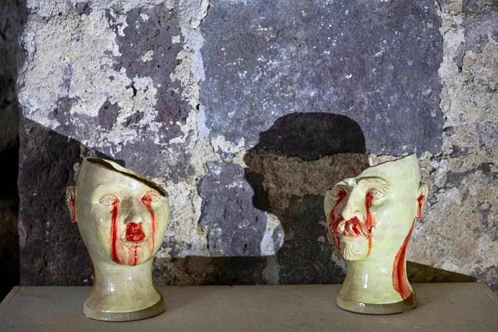 Sculture in ceramica raffiguranti Píramo e Tisbe, teste umane spezzate con dettagli rossi, opera di Niccolò Morales esposta alle Eolie al Festival EOLIè25.