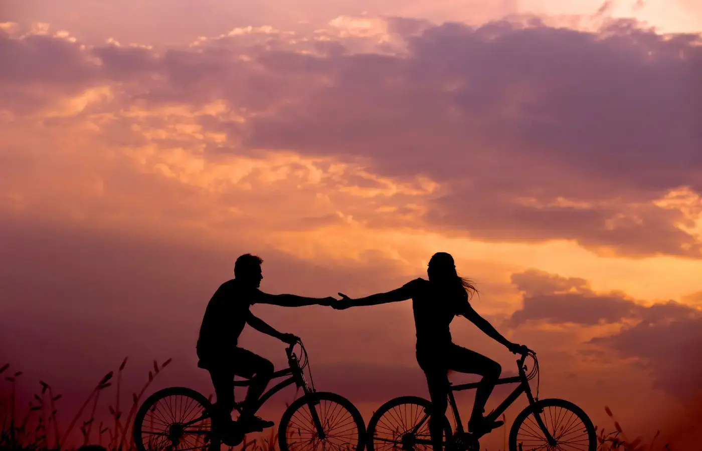 Coppia in bicicletta al tramonto alle Isole Eolie, simbolo di relazione, mistero e connessione emotiva nel festival EOLIè 2026.